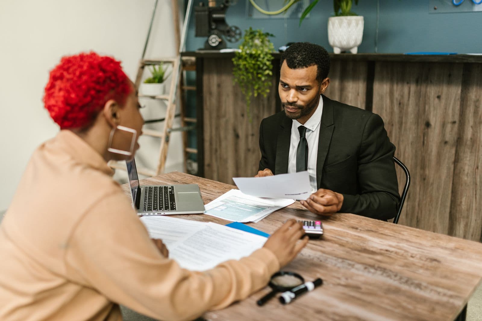 Conseiller financier en costume échangeant avec un client autour de documents