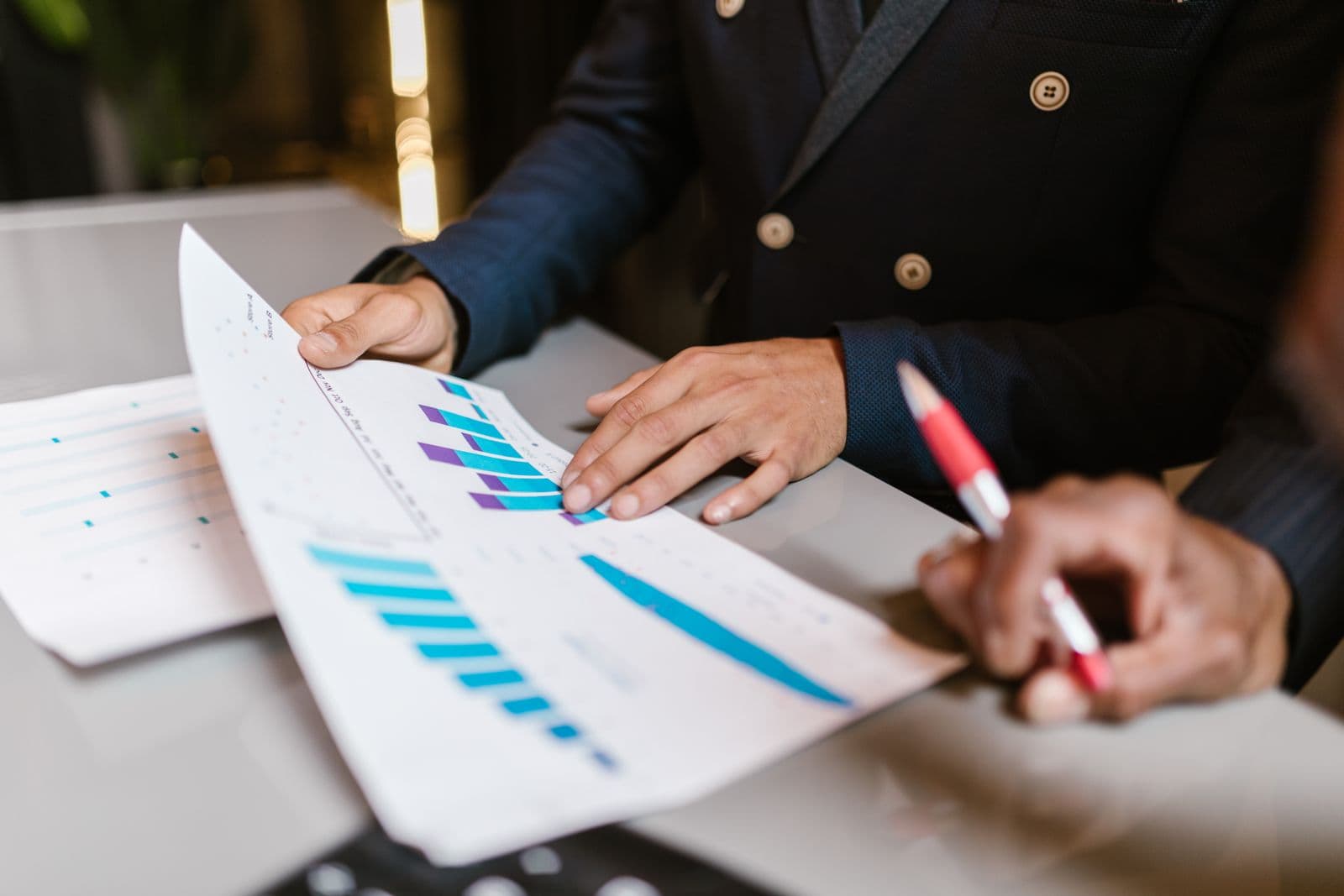 Mains tenant un rapport financier imprimé avec des graphiques